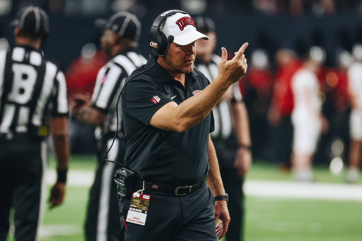 UNLV head coach Barry Odom stands on the field during a weather delay after rain leaked into Al ...