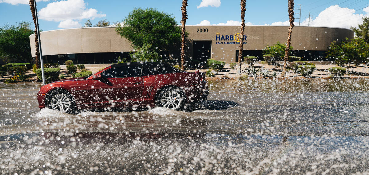 A car drives through residual flooding from recent rainfall on North Mojave Road on Sunday, Sep ...