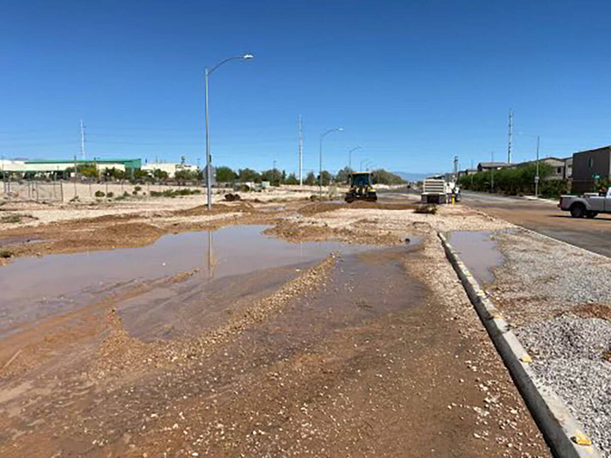 Water appears to cover part of a street as Clark County crews work to clear storm debris on Mon ...