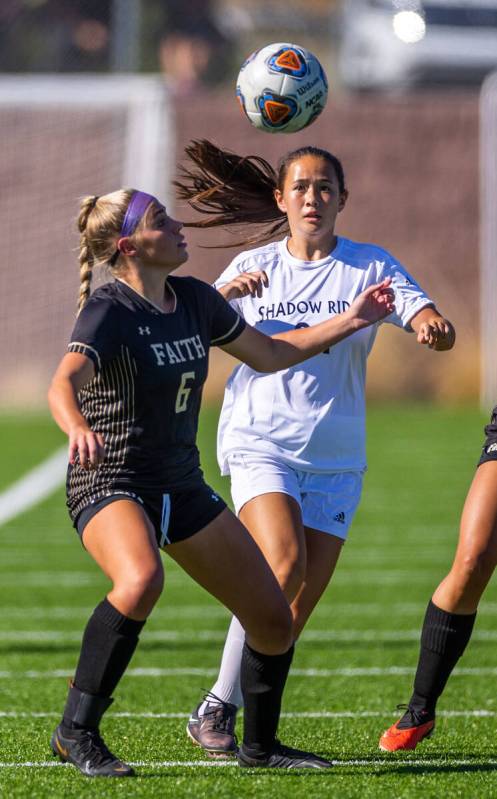 Faith Lutheran defender Jaycee Phillips (6) eyes the ball with Shadow Ridge midfielder Leighann ...