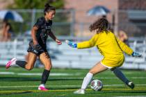 Faith Lutheran forward Riley Renteria (25) is defended on a shot attempt by Shadow Ridge goalke ...