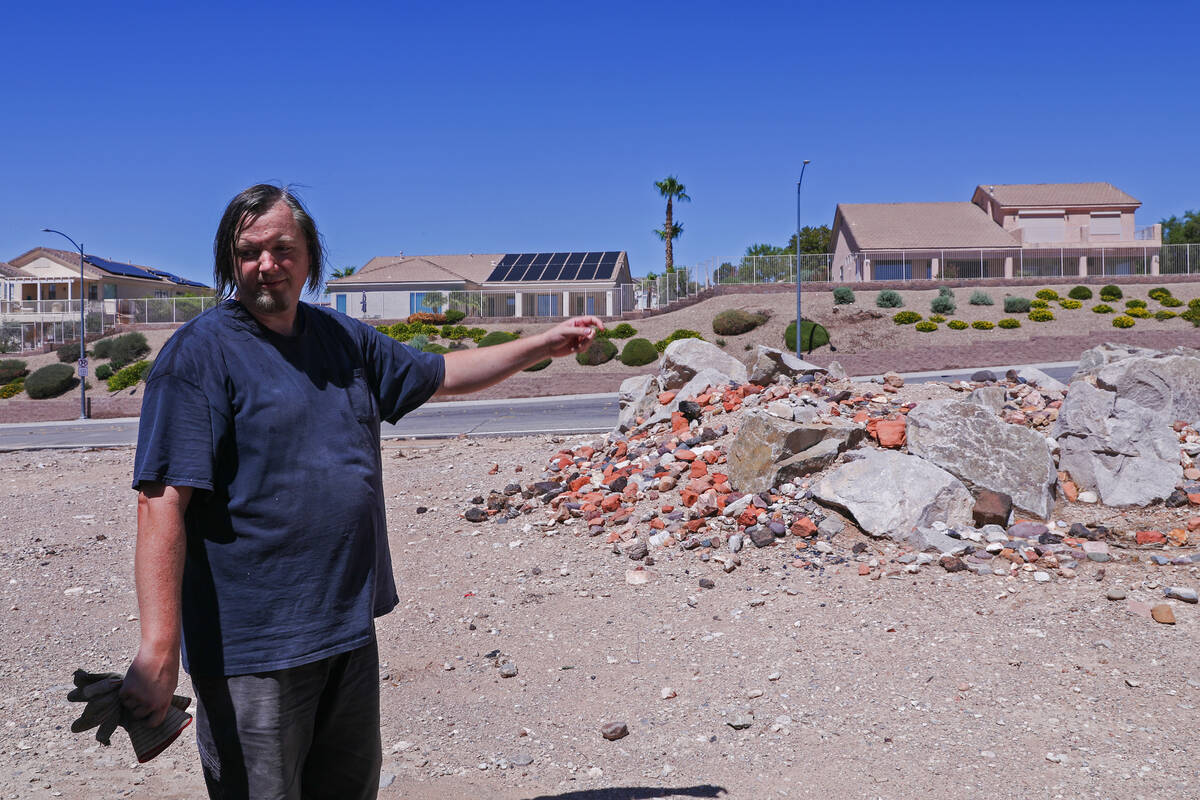 Dan Carmany surveys the debris that was pushed onto his property by flash floods that engulfed ...