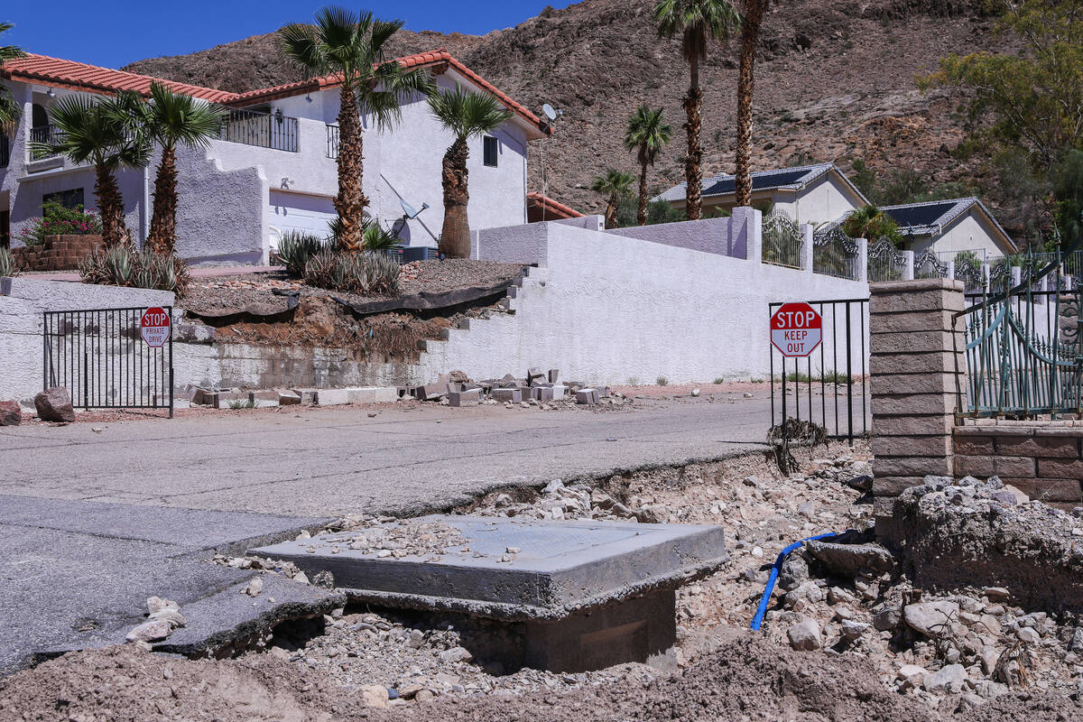 Part of a road and a residential wall are destroyed in the aftermath of the damaging flash floo ...