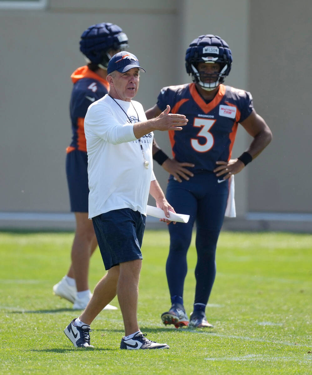 Denver Broncos head coach Sean Payton, front left, directs players as quarterback Russell Wilso ...