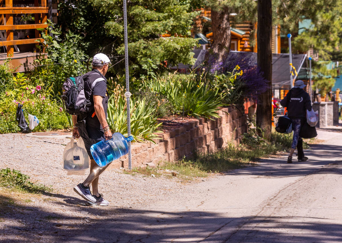 Old Town residents carry in jugs of water on Mount Charleston on Wednesday, Sept. 6, 2023, in L ...