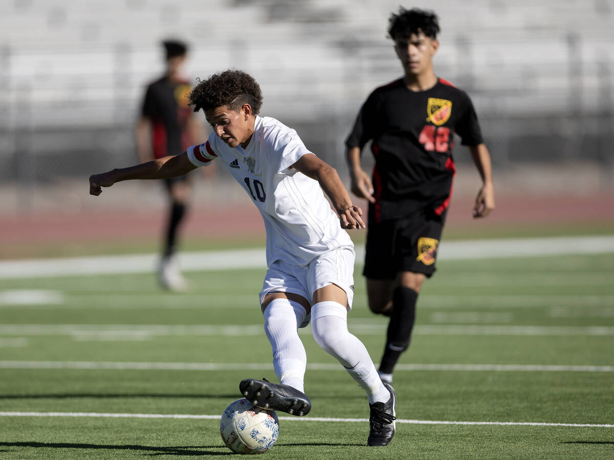 Sunrise Mountain's Michael Umana (10) dribbles up the field followed by Las Vegas' Lex Madrigal ...