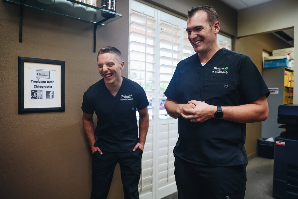 Dr. Brandon Bouwhuis, left, laughs with his colleague, Dr. Doug Brady, as they speak to a colle ...