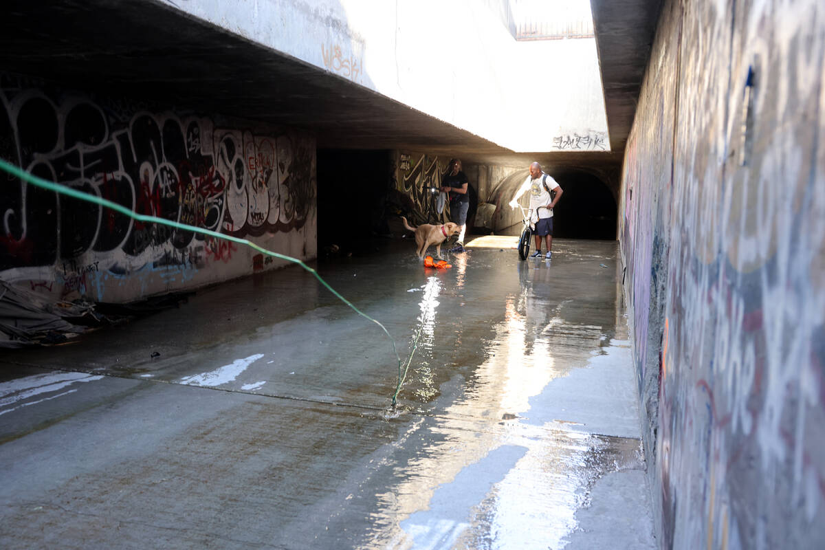 People make their way through a flood control tunnel under University Center Drive in Las Vegas ...