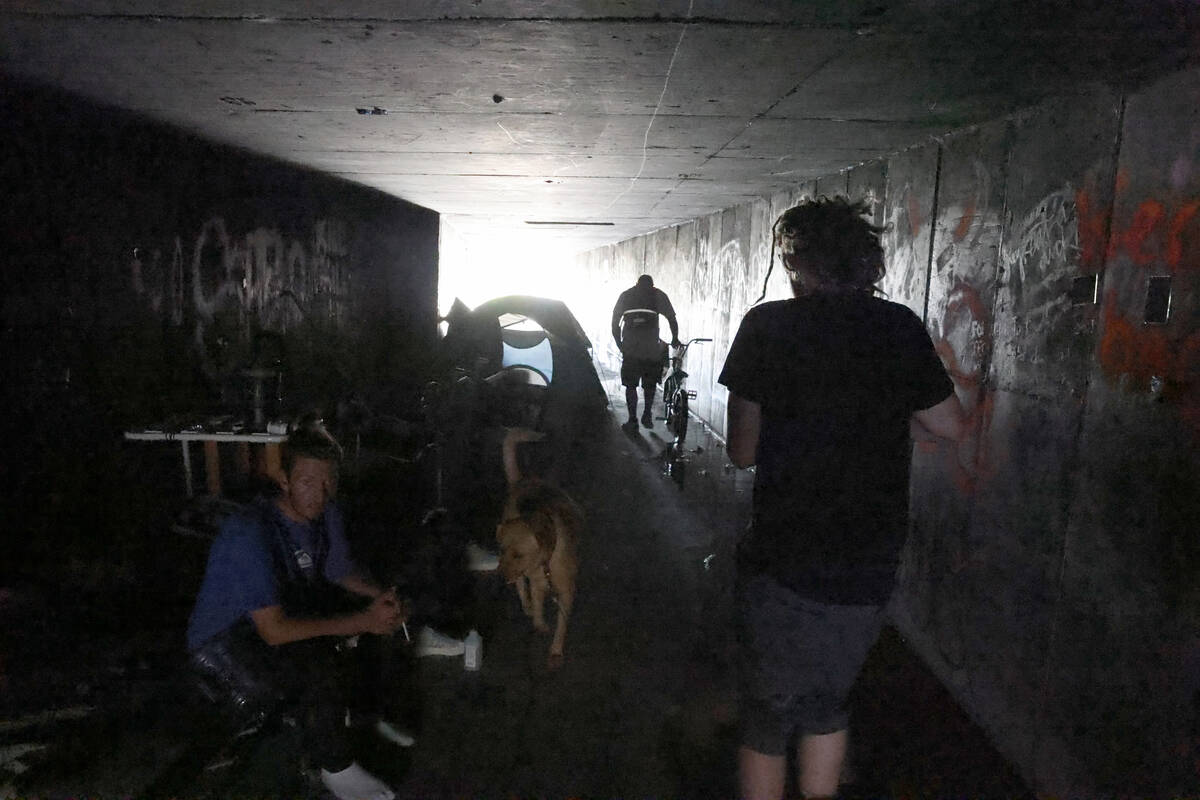 People make their way through a flood control tunnel under University Center Drive in Las Vegas ...