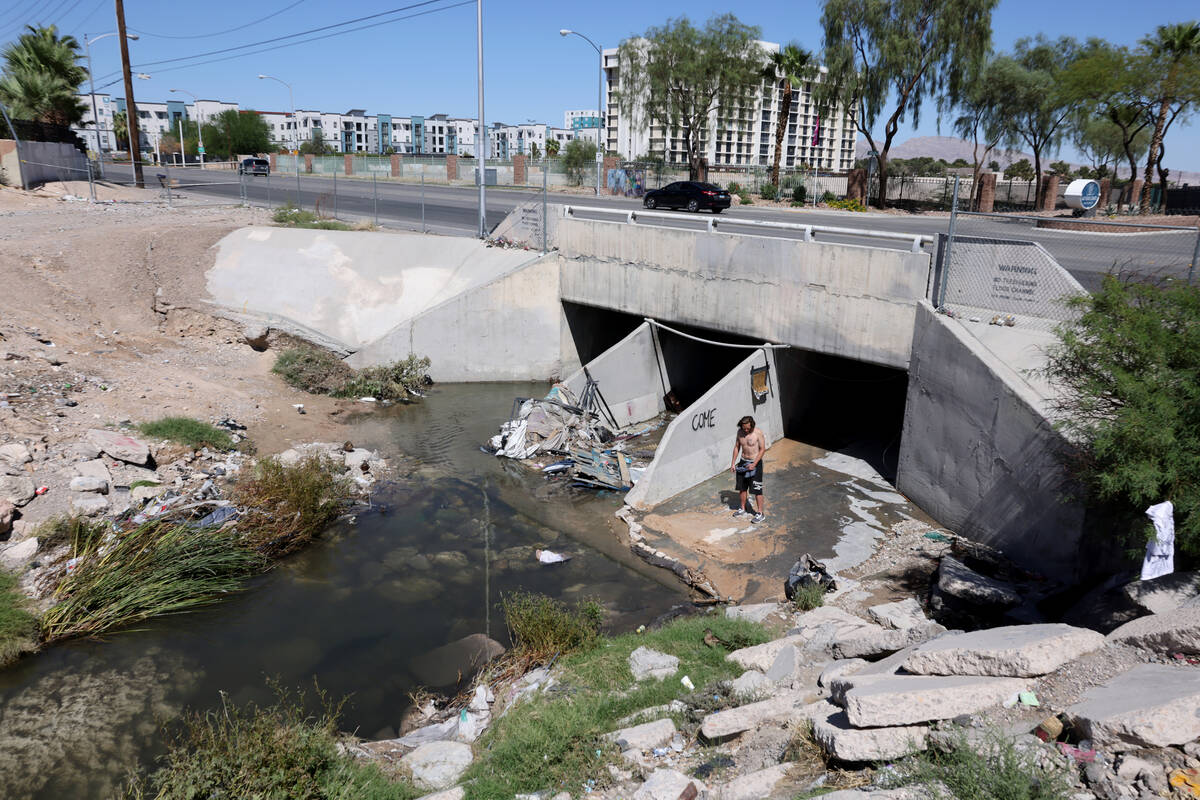 A.J., who declined to give his last name, checks on a makeshift levy he built to divert water f ...