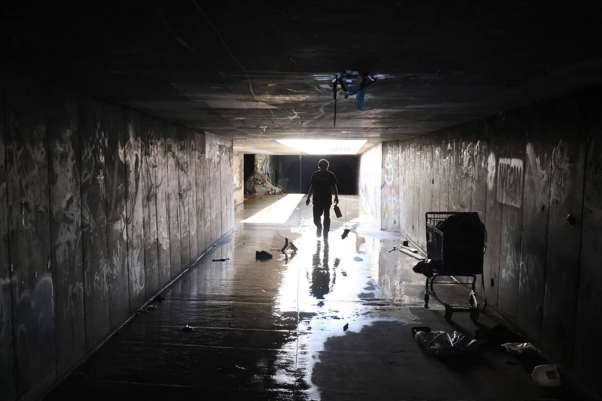 A person who declined to give their name walks in a flood control tunnel under University Cente ...