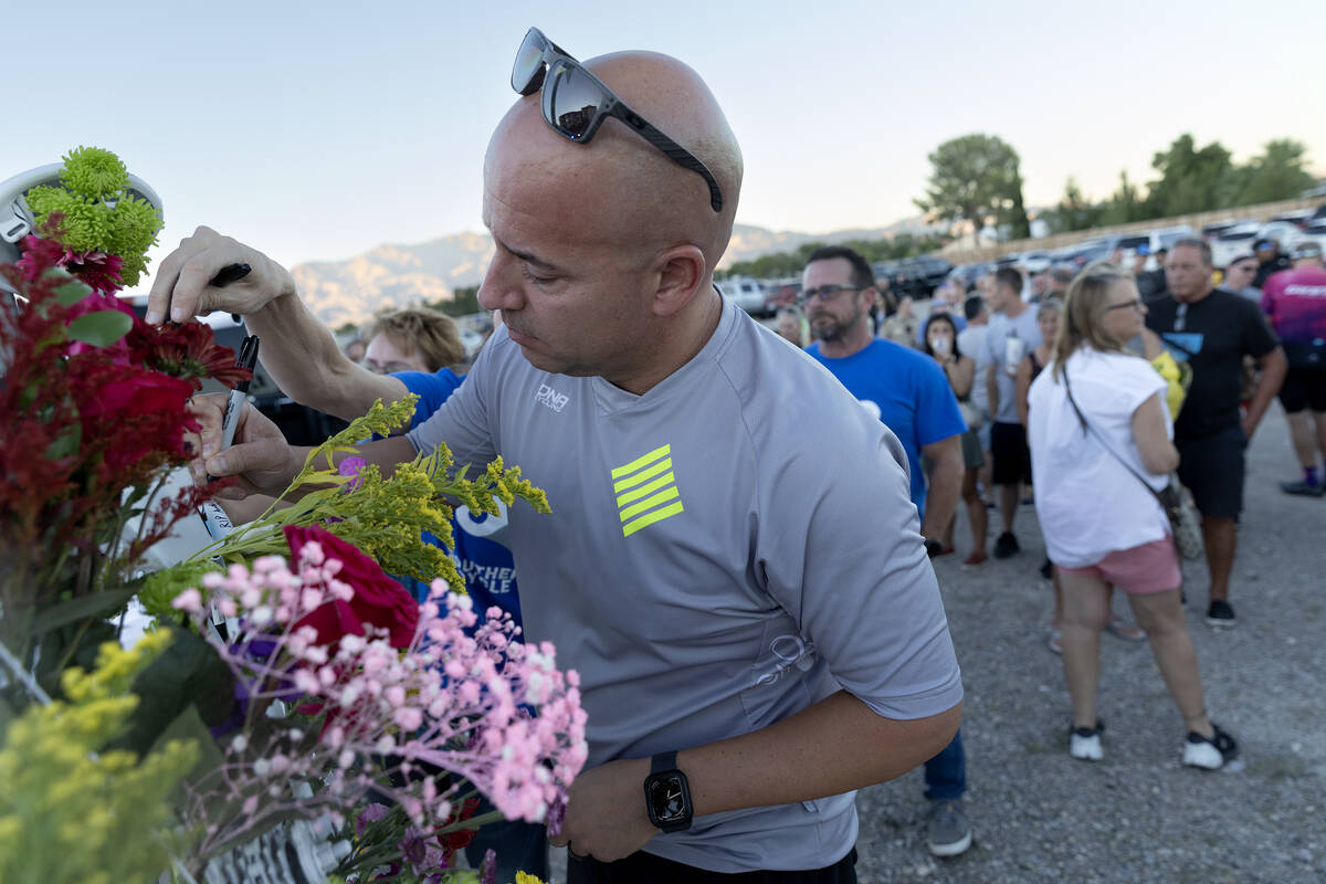 Paul Manguel, a cyclist from Henderson, signs a memorial for Andreas Probst during a memorial n ...