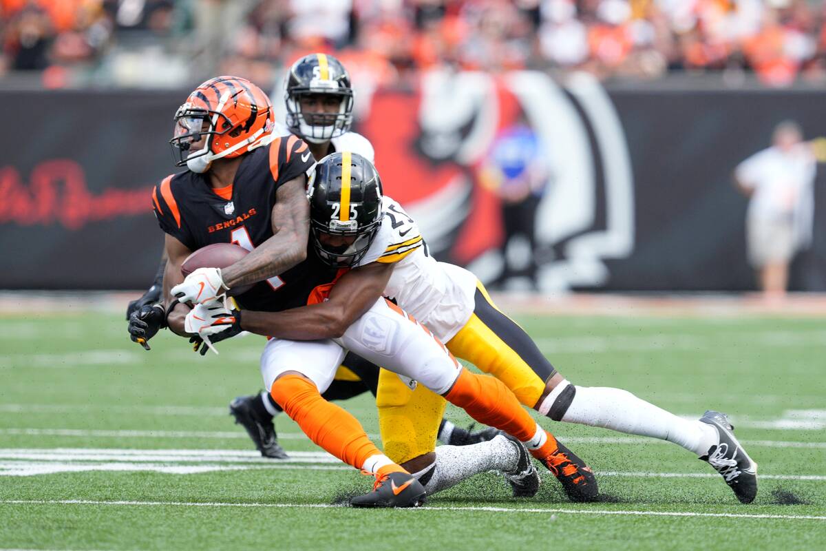 Cincinnati Bengals wide receiver Ja'Marr Chase (1) is tackled by Pittsburgh Steelers cornerback ...