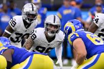 Las Vegas Raiders defensive end Maxx Crosby, center, and cornerback Nate Hobbs (39) line up aga ...