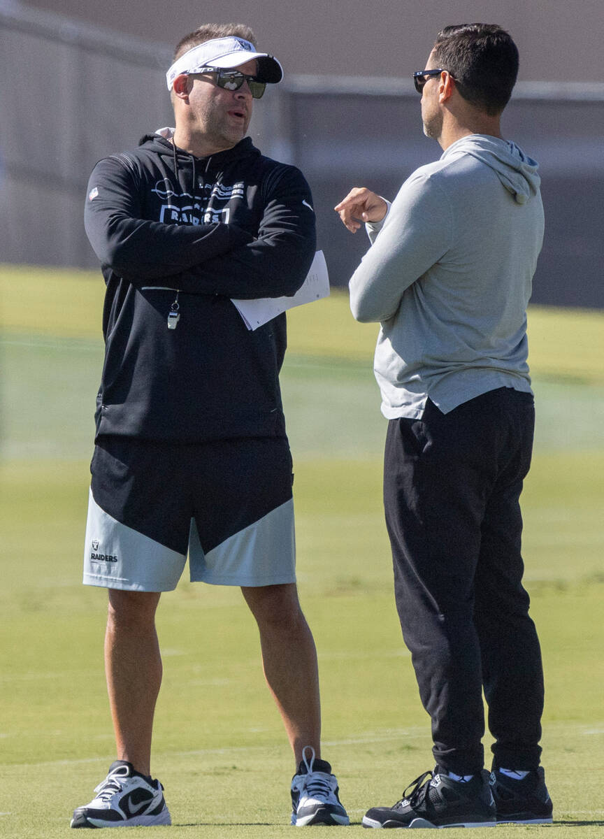 Raiders head coach Josh McDaniels, left, and general manager Dave Ziegler meet during practice ...