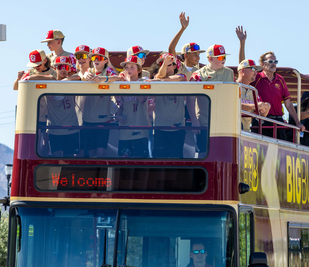 The Henderson Little League team and coaches wave to fans along the parade route on the way to ...