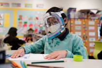 FILE - A student wears a mask and face shield in a 4th grade class amid the COVID-19 pandemic a ...
