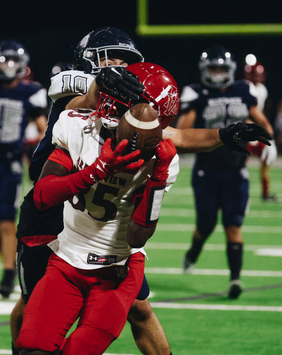 Shadow Ridge cornerback Tanner McDonald (10) grabs onto Arbor View wide receiver Mekhi Mitchell ...