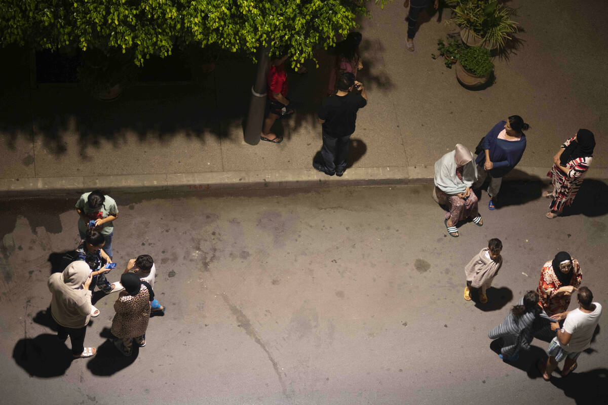 People take shelter and check for news on their mobile phones after an earthquake in Rabat, Mor ...