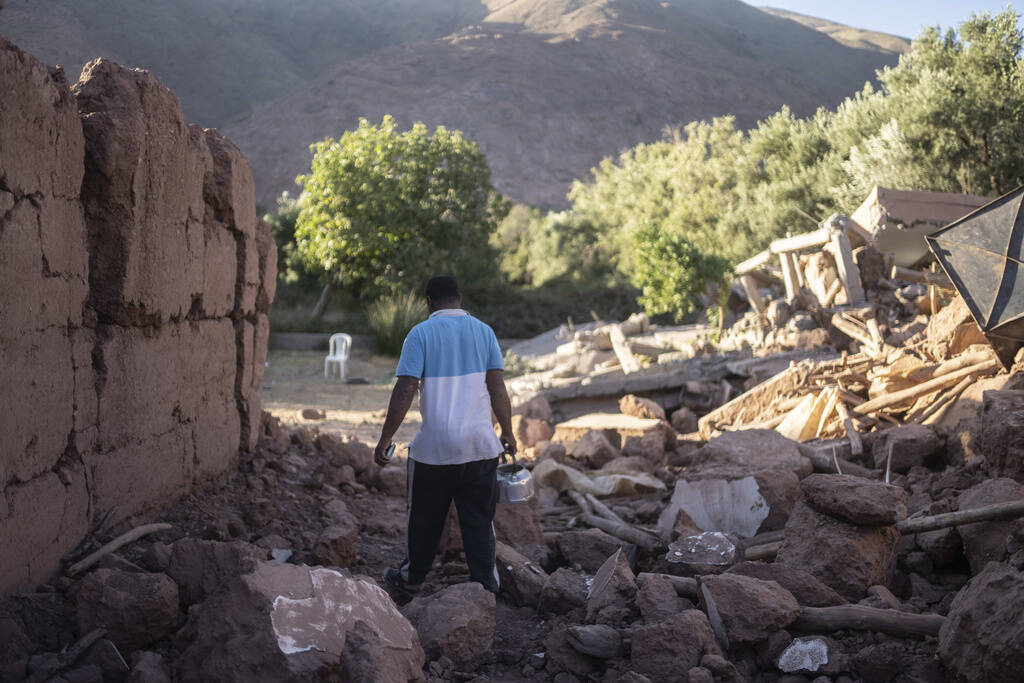 Mohammed Elhmatif walks amidst the rubble of his home which was damaged by the earthquake, in I ...