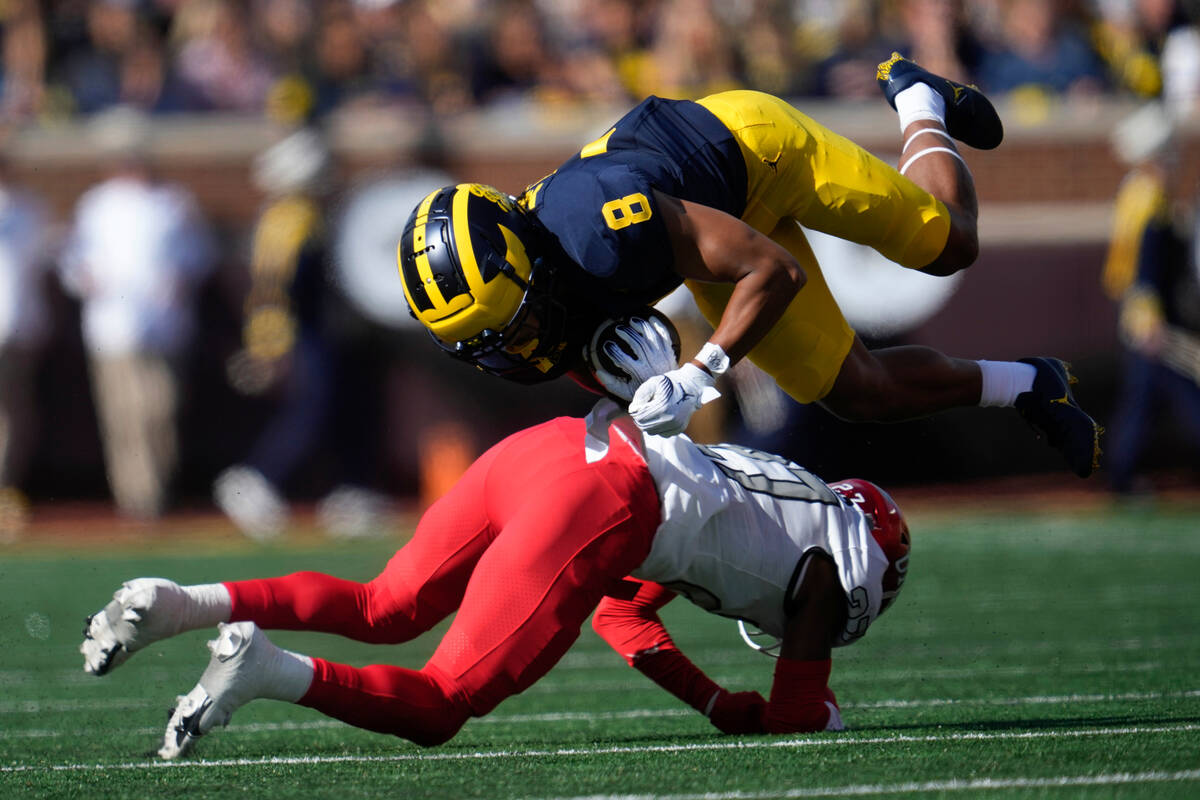 Michigan wide receiver Tyler Morris (8) is brought down after a reception by UNLV defensive bac ...
