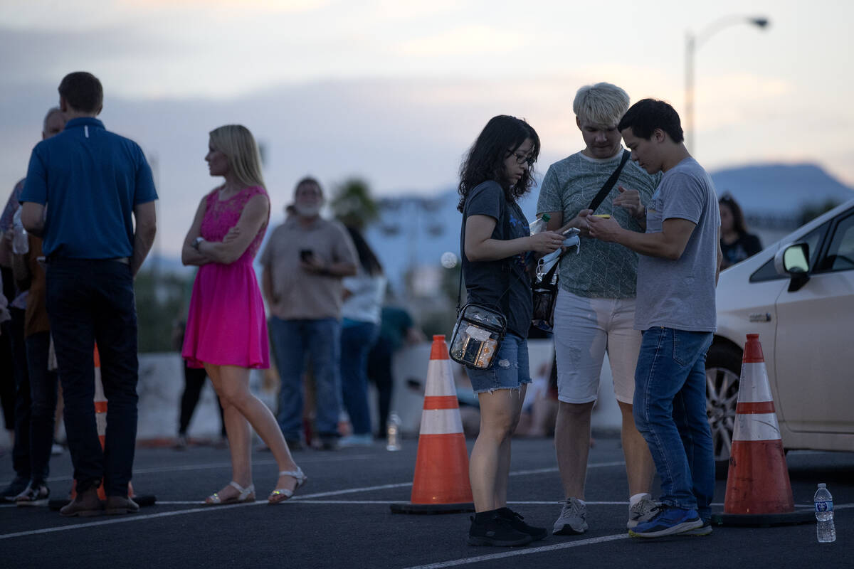 Concertgoers wait for ride shares near Allegiant Stadium after Ed Sheeran canceled his concert ...