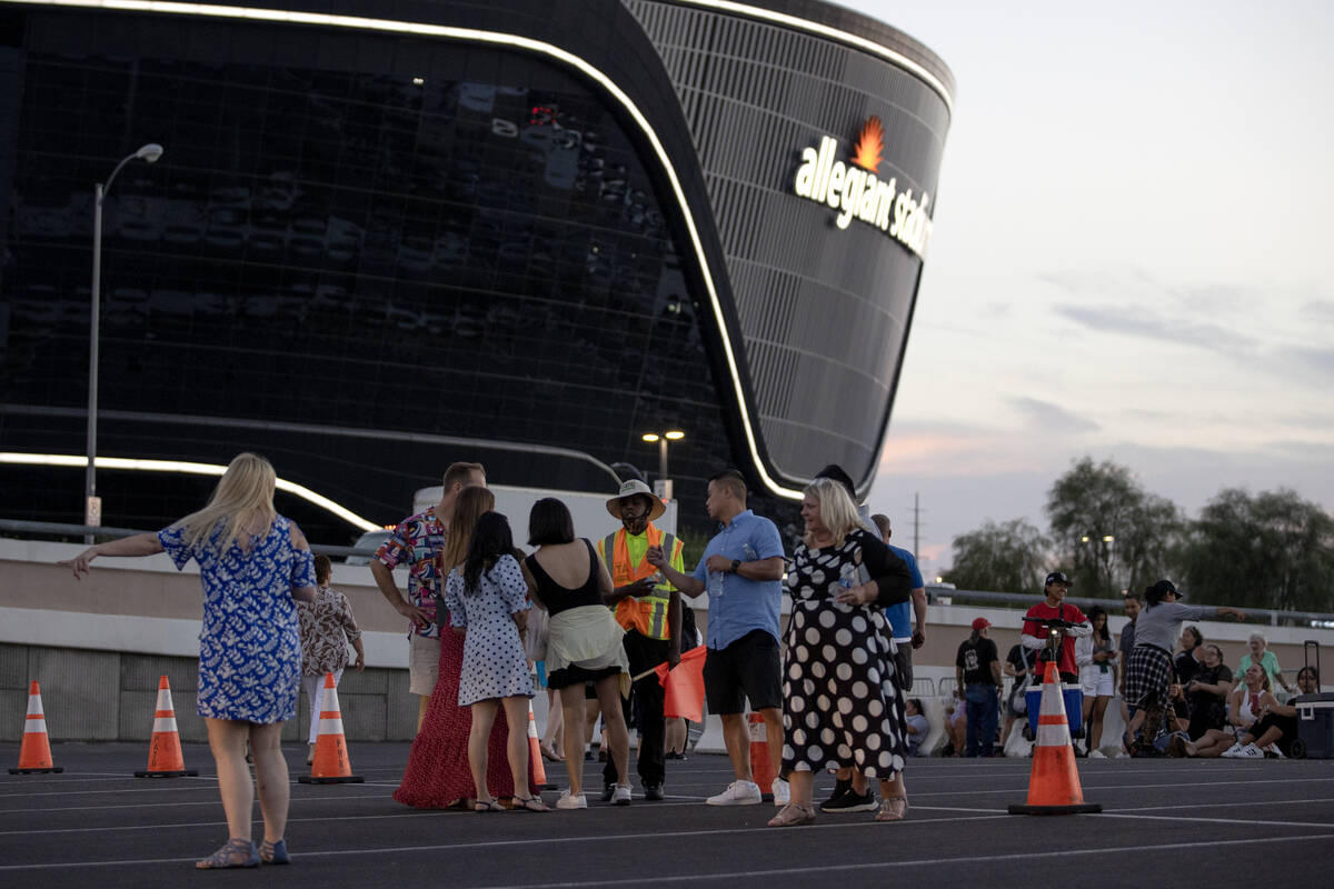 Concertgoers wait for ride shares near Allegiant Stadium after Ed Sheeran canceled his concert ...