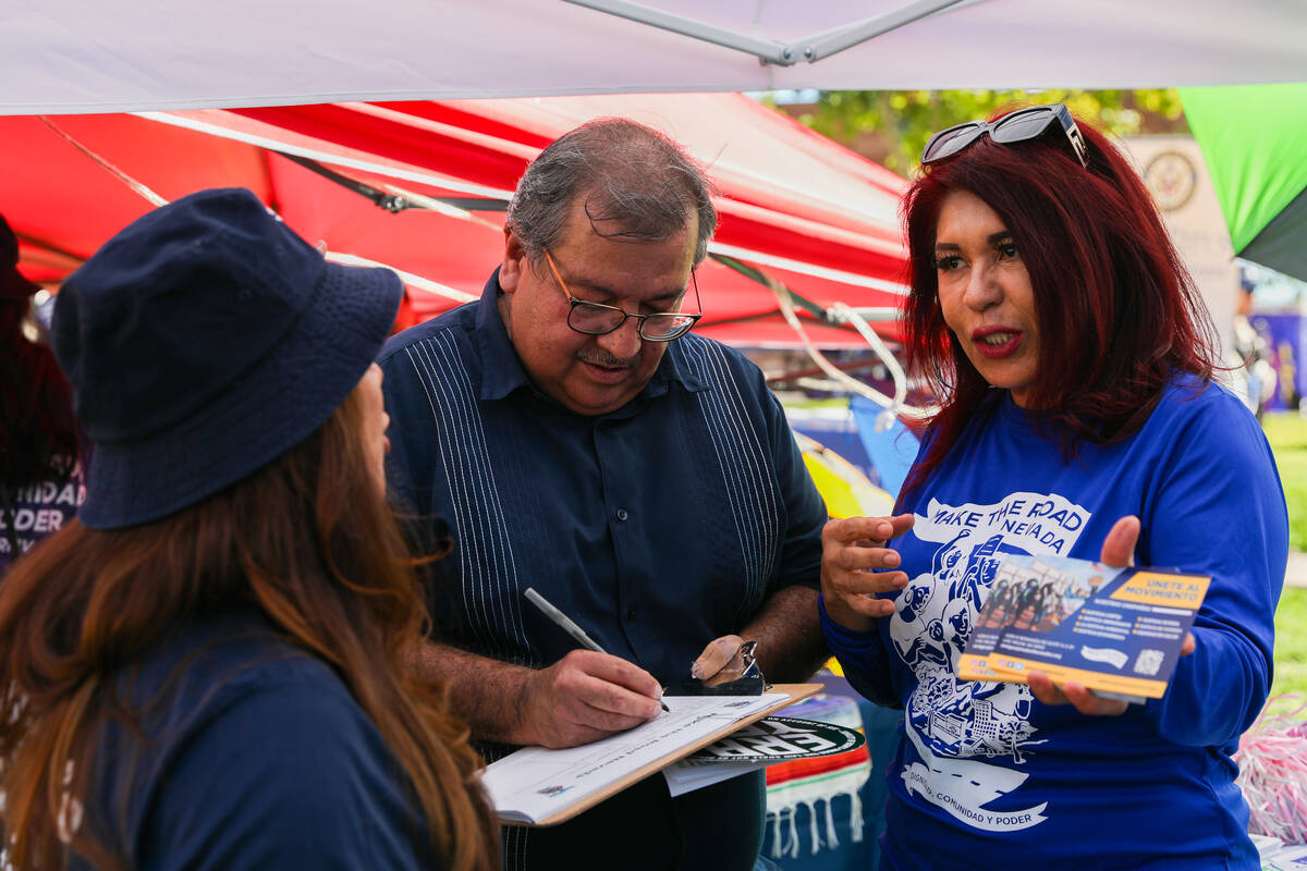 Maria Navarrete, right, speaks with local residents, including Jorge Elizondo, center, at her b ...
