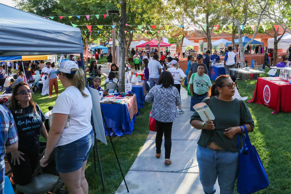 People walk through the booths of different cultural organizations at the Communities United, R ...