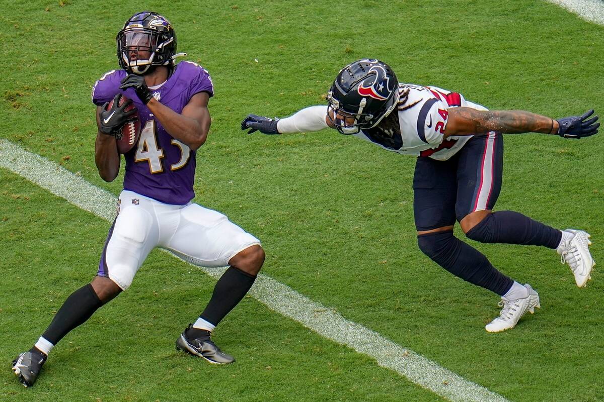 Baltimore Ravens' Justice Hill runs past Houston Texans' Derek Stingley Jr. for a touchdown dur ...