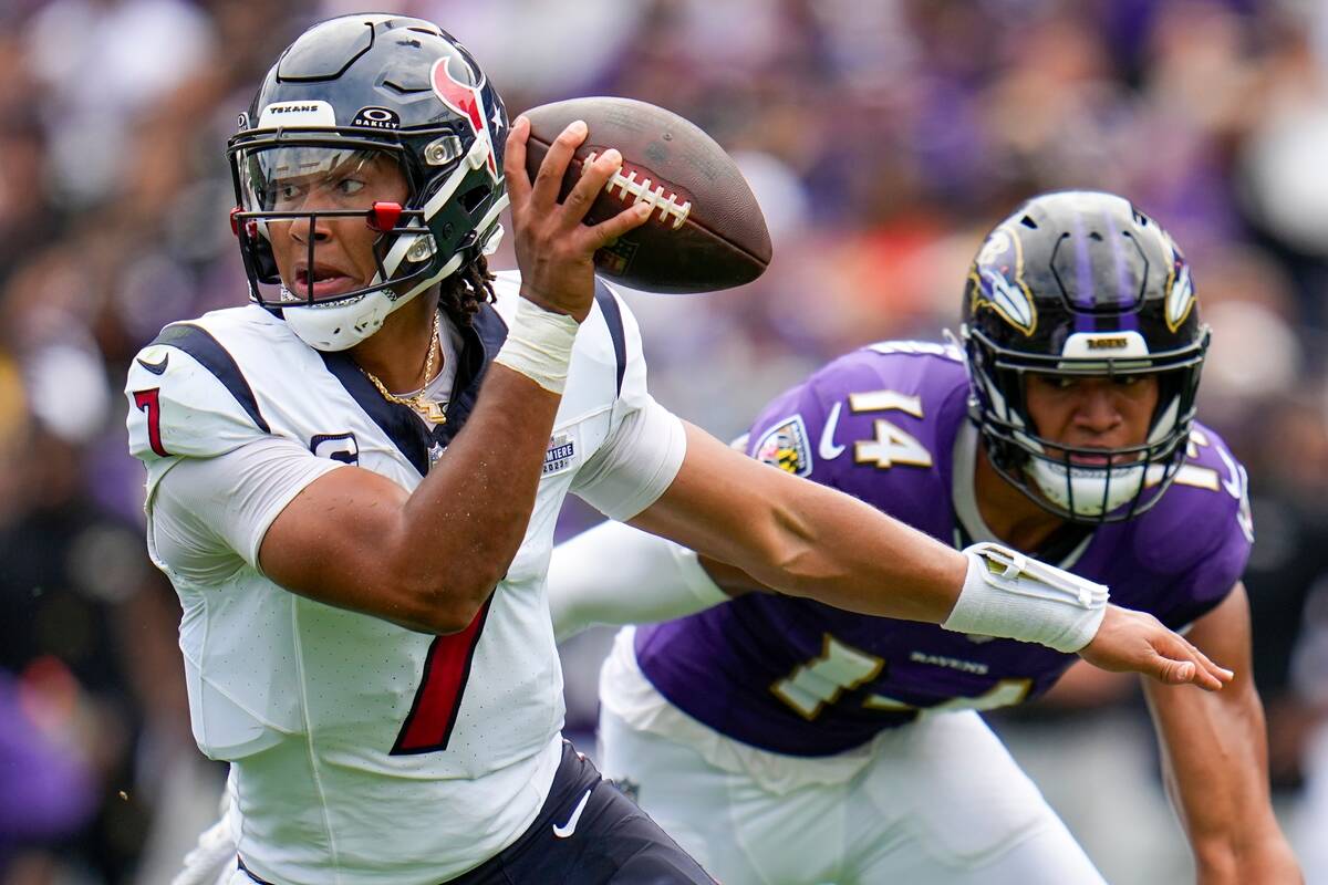 Houston Texans' C.J. Stroud gets past Baltimore Ravens' Kyle Hamilton during the first half of ...