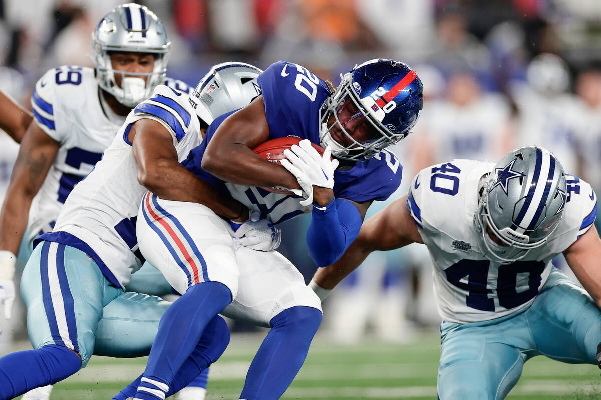 New York Giants' Eric Gray, center, carries the ball during the first half of an NFL football g ...