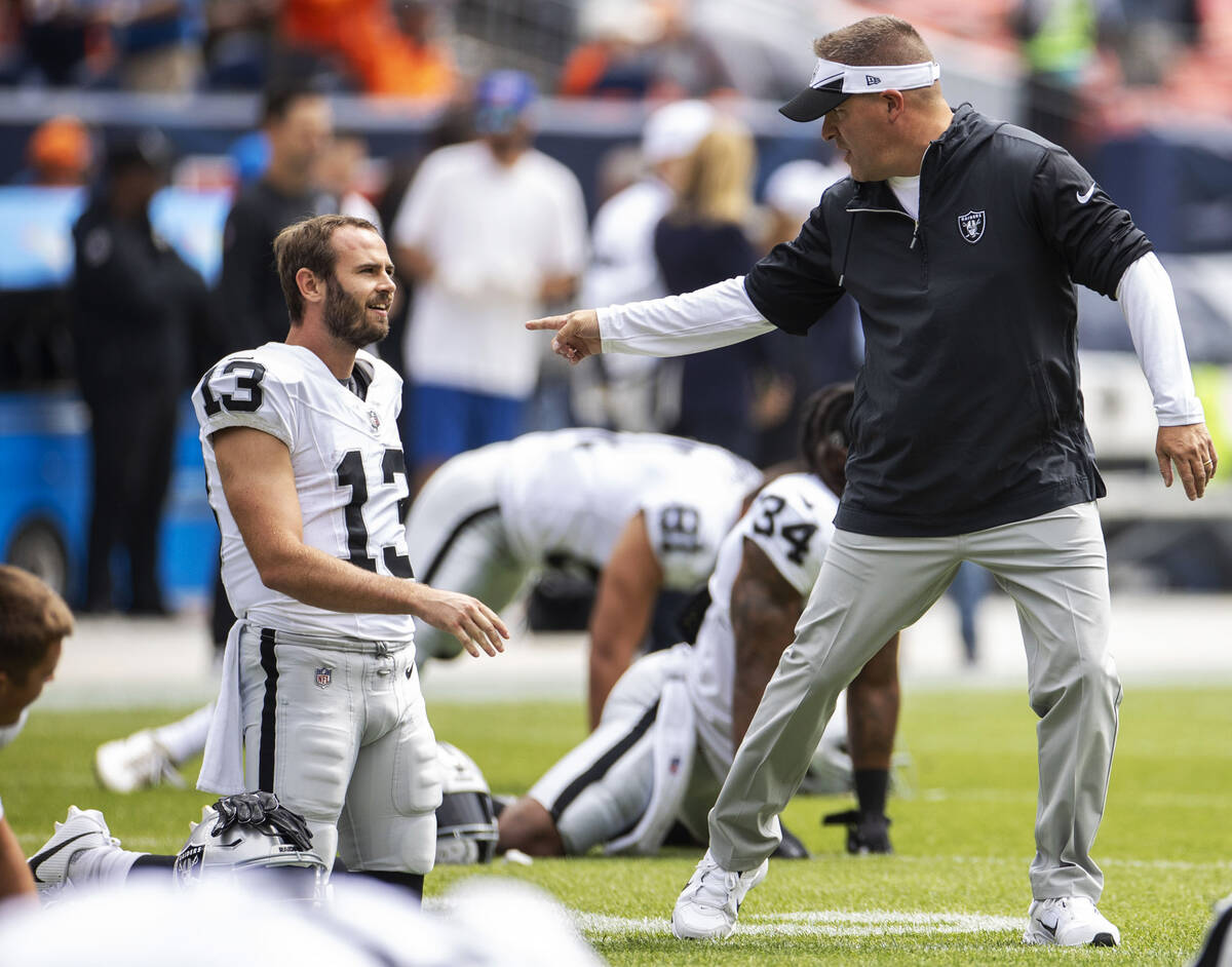 Raiders head coach Josh McDaniels points to wide receiver Hunter Renfrow (13) as he stretches b ...