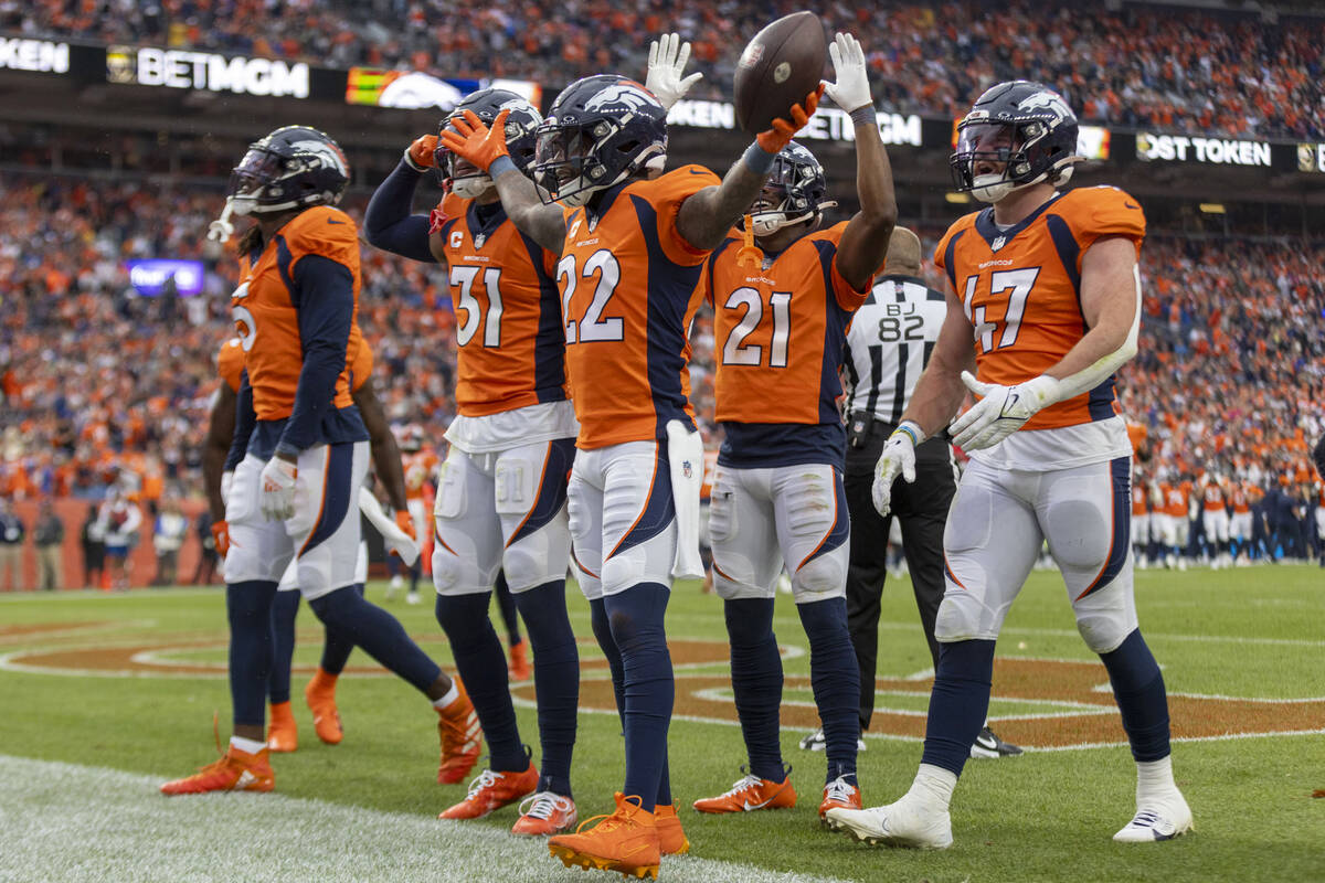 The Denver Broncos celebrate safety Kareem Jackson’s (22) interception during the second ...