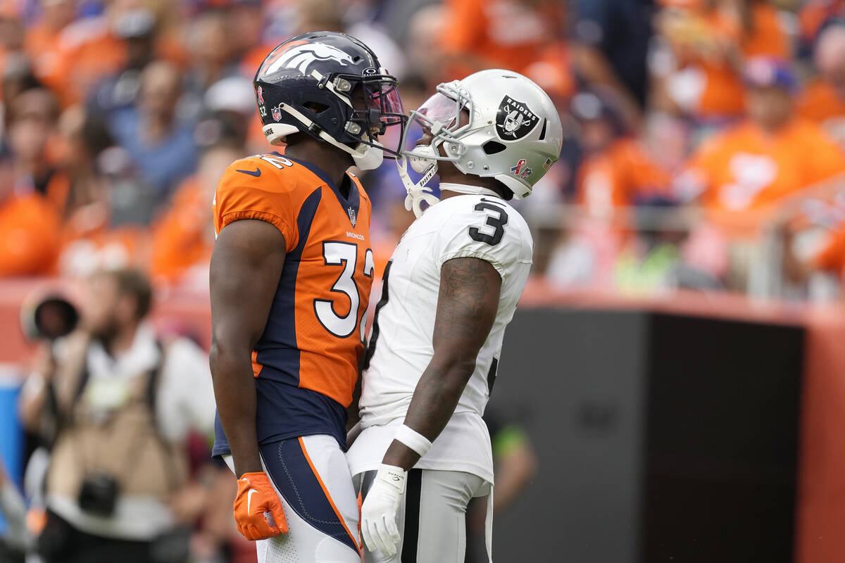 Denver Broncos safety Delarrin Turner-Yell, left, and Las Vegas Raiders wide receiver DeAndre C ...