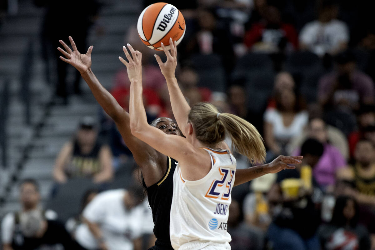 Las Vegas Aces guard Jackie Young, behind, jumps to block Phoenix Mercury guard Ashley Joens (2 ...