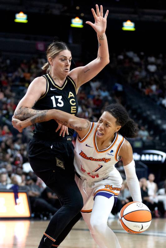 Phoenix Mercury guard Sug Sutton (1) passes around Las Vegas Aces forward Cayla George (13) dur ...