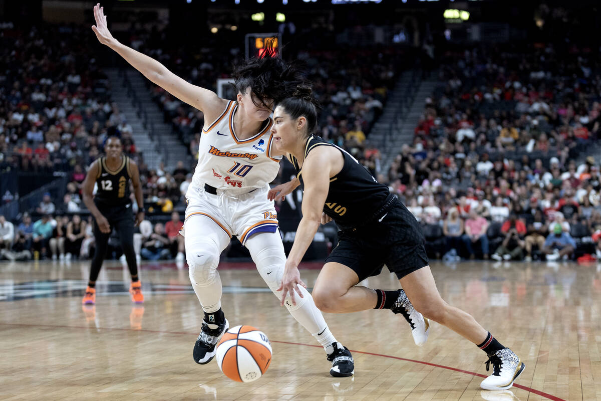 Las Vegas Aces guard Kelsey Plum (10) dribbles around Phoenix Mercury center Megan Gustafson (1 ...