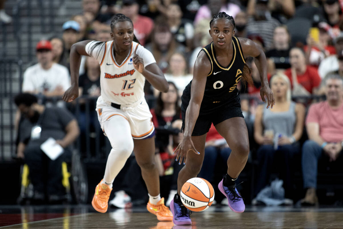 Las Vegas Aces guard Jackie Young (0) dribbles up the court followed by Phoenix Mercury forward ...