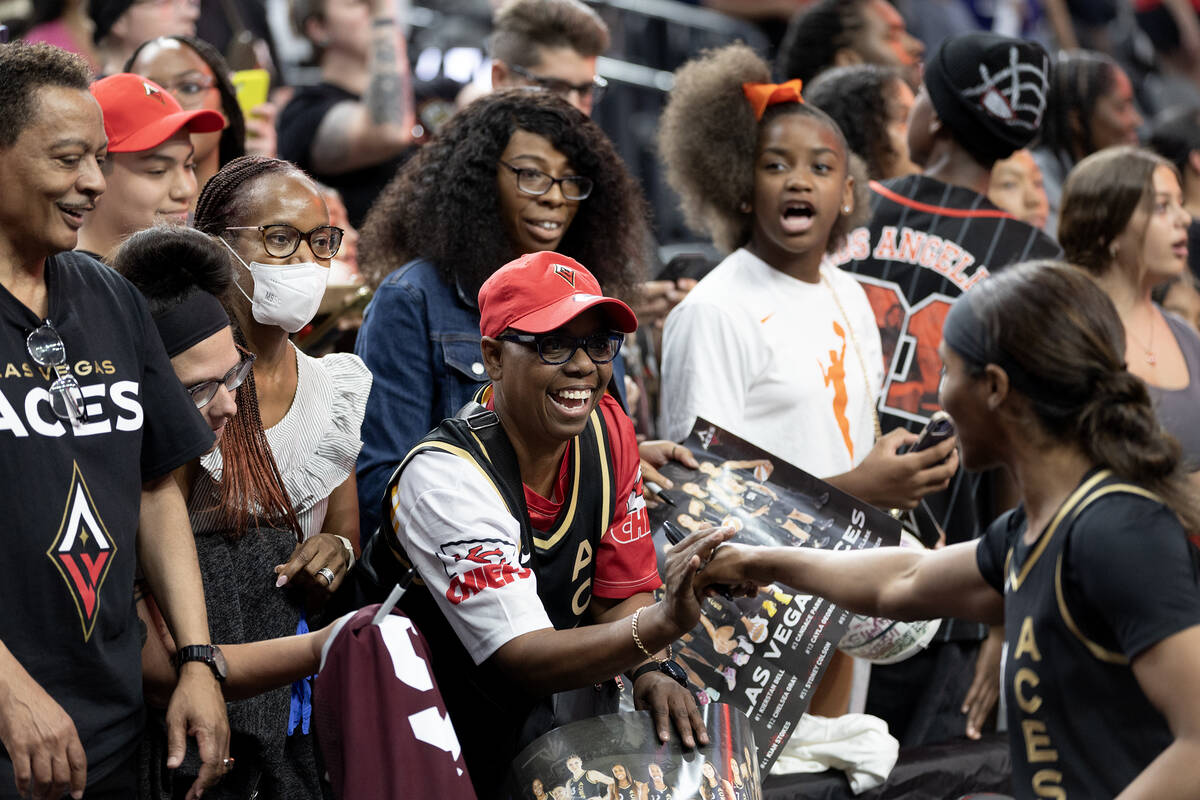 A fan gates an autograph from Las Vegas Aces guard Sydney Colson (51) after the Aces won a WNBA ...