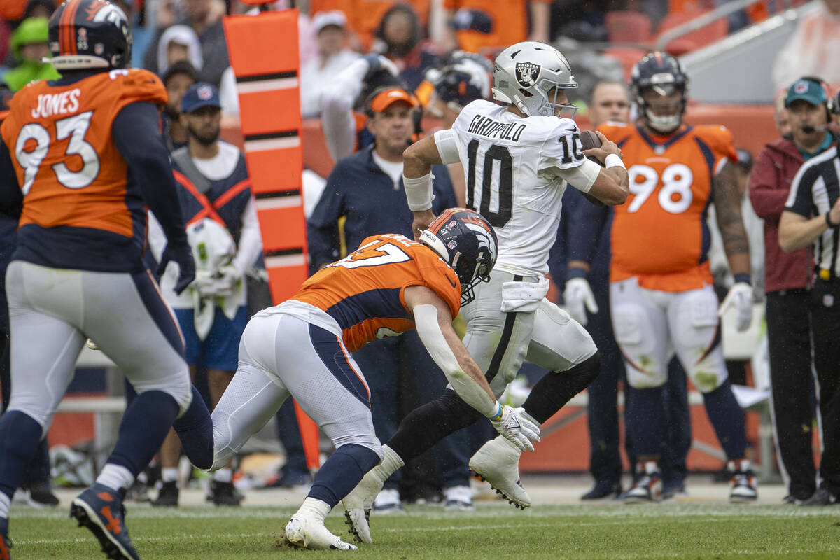 Raiders quarterback Jimmy Garoppolo (10) escapes a tackle by Denver Broncos linebacker Josey Je ...