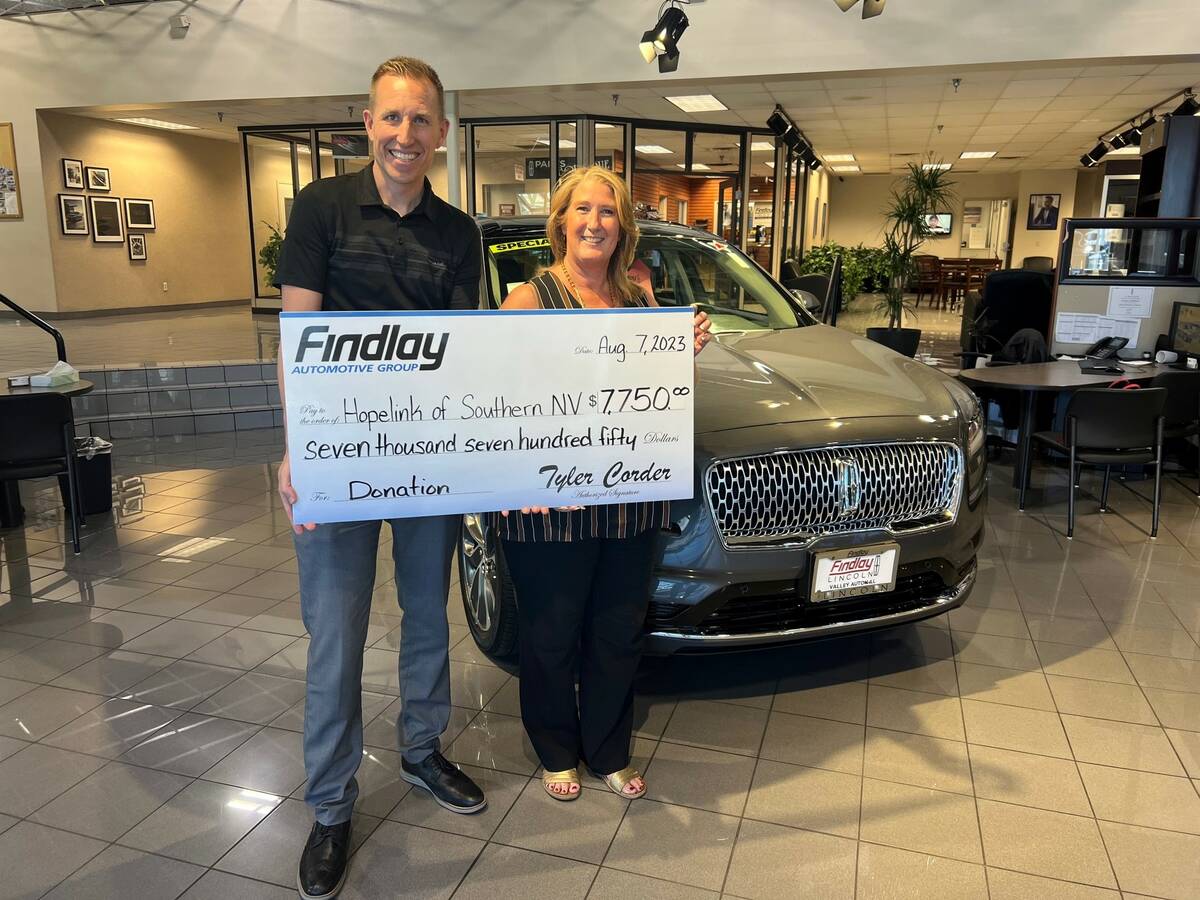 Jeff Giles, marketing director for Findlay Automotive, presents a check to Stacey Lockhart, CEO ...