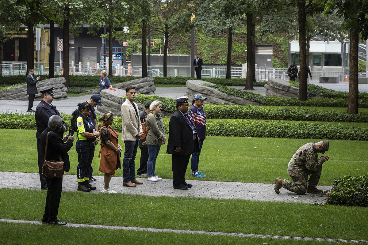 People pray before the commemoration ceremony on the 22nd anniversary of the September 11, 2001 ...