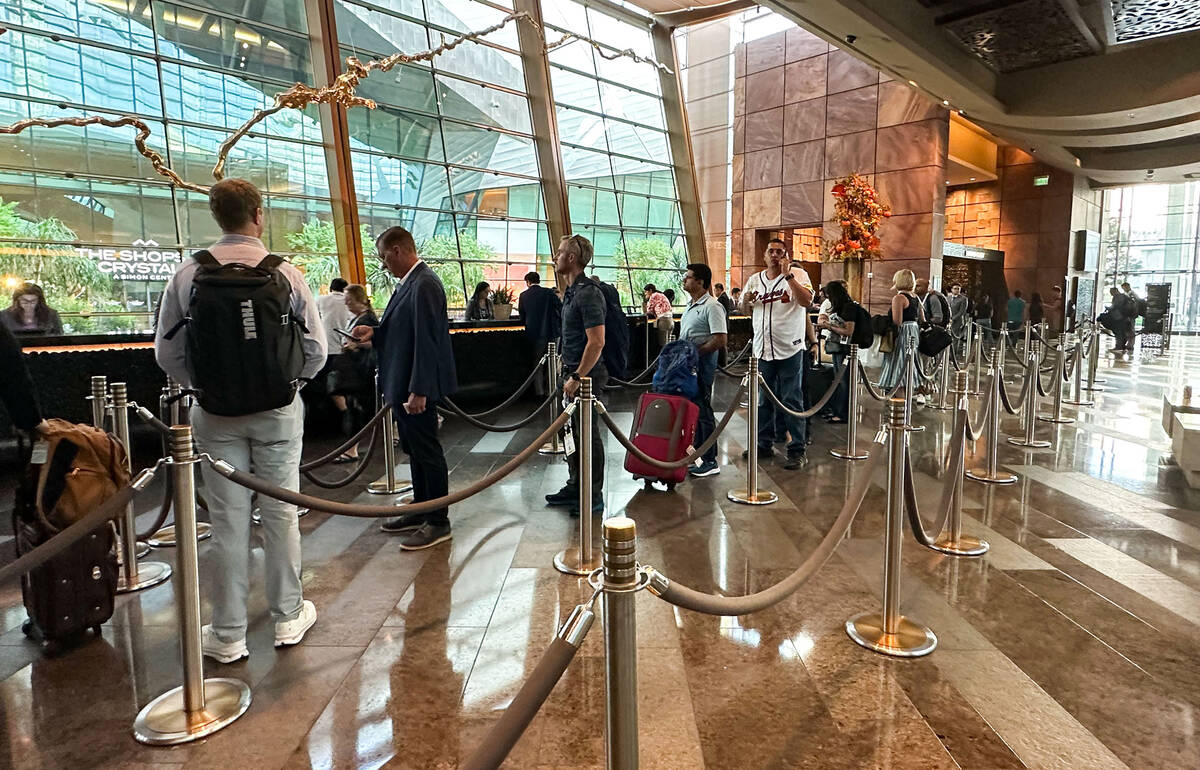 Long lines persist at the check-in for Aria Resort and Casino after MGM Resorts International s ...