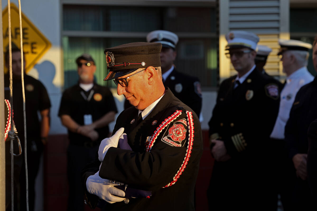 Las Vegas Firefighters Local 1285 Honor Guard member Ron Kline prepares to raise an American fl ...