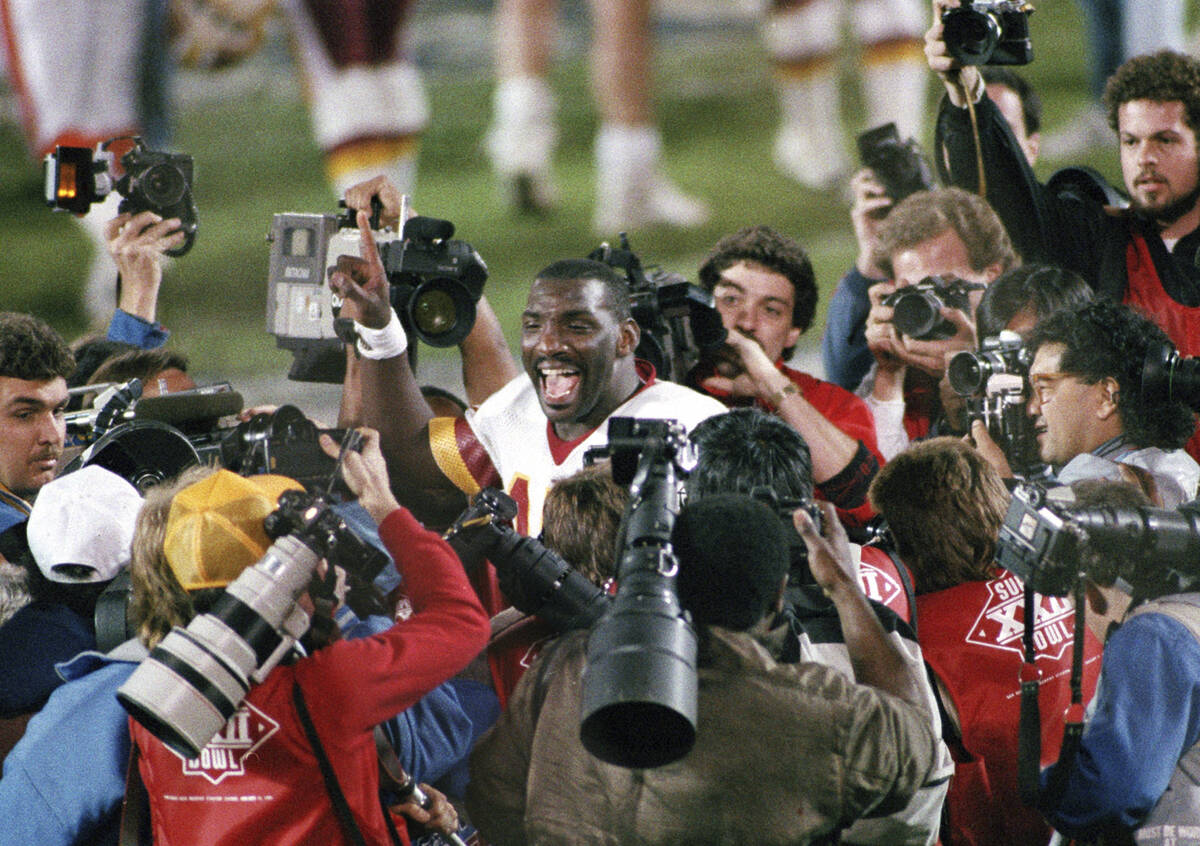 FILE - Washington Redskins quarterback Doug Williams is surrounded by members of the media afte ...