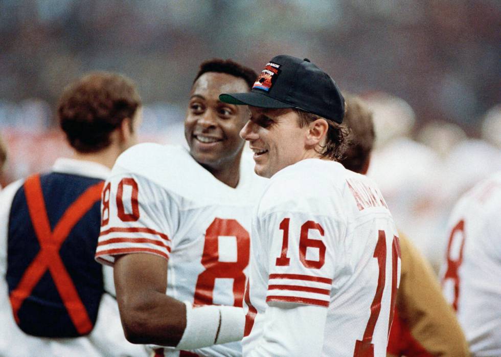 San Francisco 49ers quarterback Joe Montana (16) chats with wide receiver Jerry Rice late in Su ...