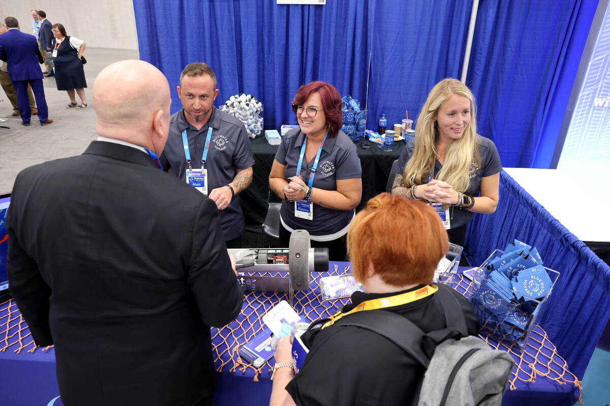 Matt Greene, from left, Katrina Newby and Sara Lucia, of Bluewater Voyage, talk to conventionee ...