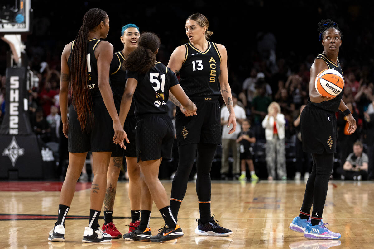 Las Vegas Aces guard Chelsea Gray, right, eyes the hoop while her teammates celebrate their win ...