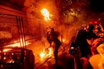 Protesters throw flaming debris over a fence at the Mark O. Hatfield United States Courthouse o ...